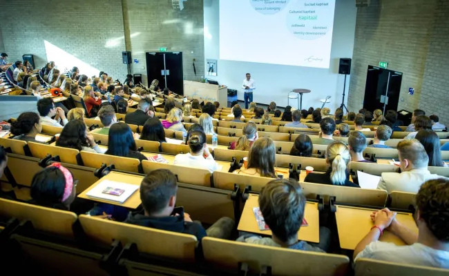 Docent geeft les in een grote collegezaal