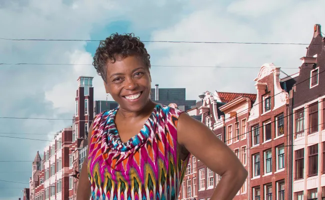 Vrolijke vrouw poseert voor Nederlands straatbeeld.