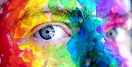 Gezicht beschilderd met regenboogkleuren 
