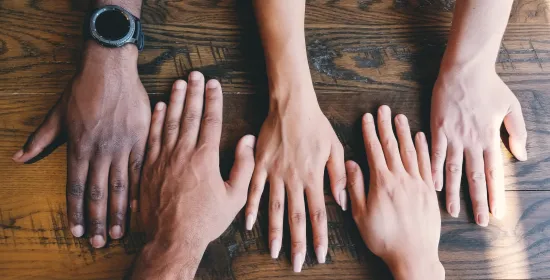 Verschillende handen bij elkaar op tafel