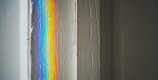 Foto van een regenboog op een wit vensterkozijn
