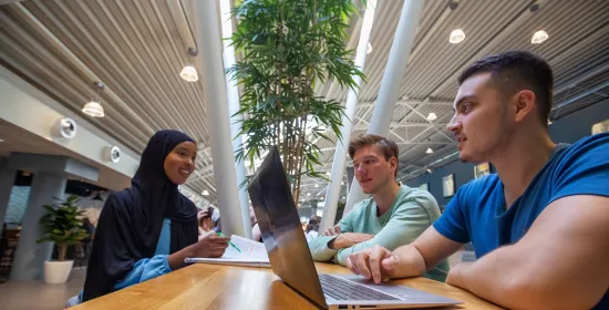 Studenten aan tafel met laptop in De Refter