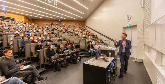 Volle collegezaal met professor voor de zaal