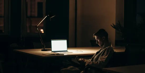 Man in donkere kamer met laptop