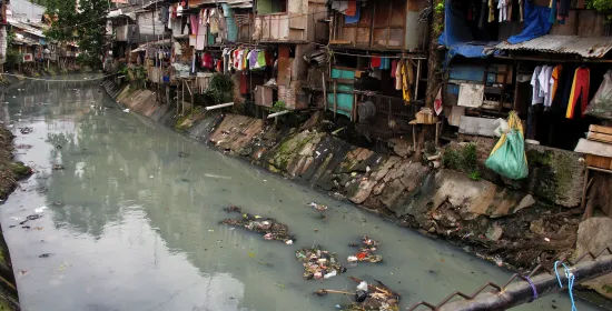 Slum housing next to a polluted stream in Indonesia