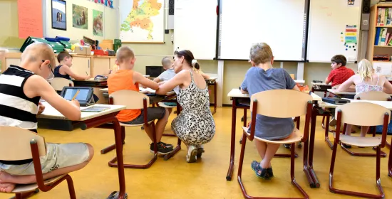 Kinderen in een klaslokaal onder begeleiding van een leraar