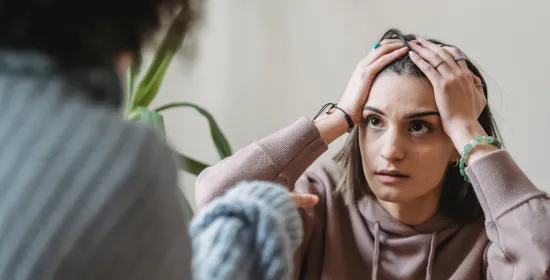 Vrouw zit met de handen in het haar