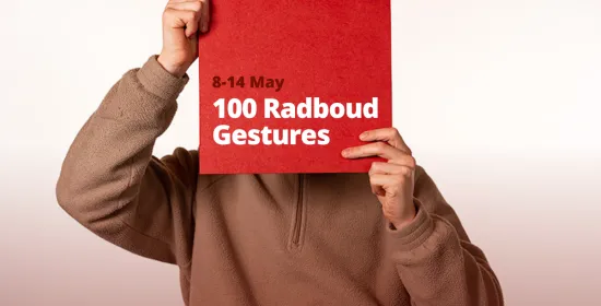 Person holding a Radboud gebaren poster