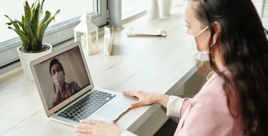 Two people video calling each other with face masks on