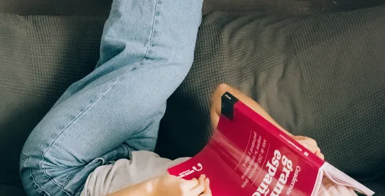Girl reading a Spanish textbook upside down