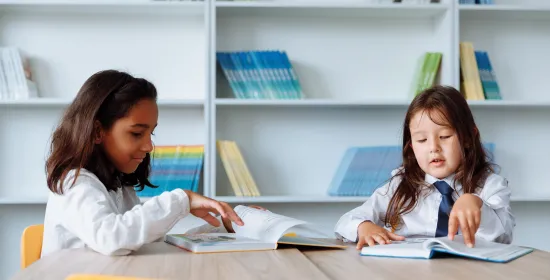 Two young children reading a book