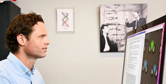Hoogleraar Tom de Greef kijkt naar een computerscherm met beeld van DNA-dataopslag