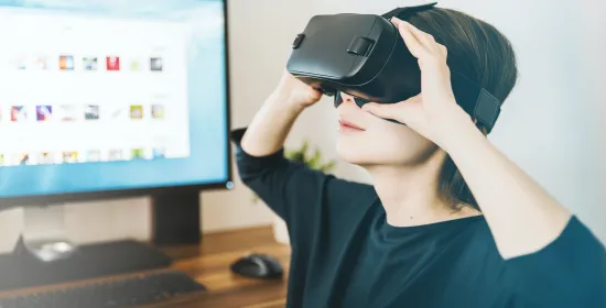Kind met virtual reality-bril op, met een monitor naast het kind