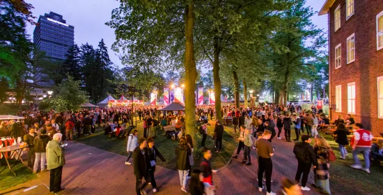 Foto van vol grasveld en podium naast Berchmanianum tijdens Radboud Festival