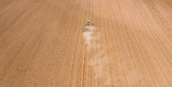 Modern backhoe ploughing agricultural field