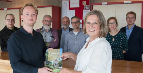 Wouter Kock overhandigt het eerste exemplaar van Loss in Translation aan decaan Heleen Murre-van den Berg