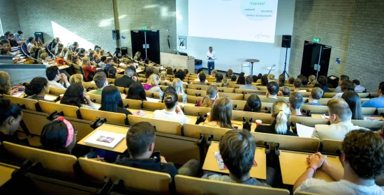 Docent geeft les in een grote collegezaal