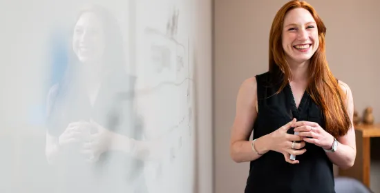 Vrouw geeft een presentatie naast een whiteboard