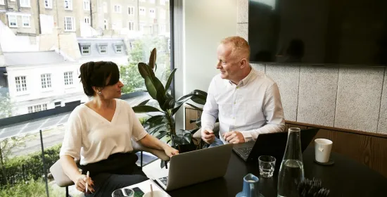 Man en vrouw overleggen zittend voor een raam