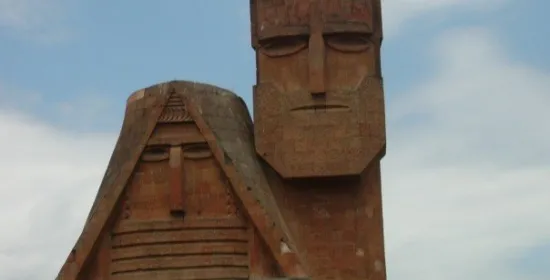 A monument consisting of two large faces made of stone called "We are our mountains".