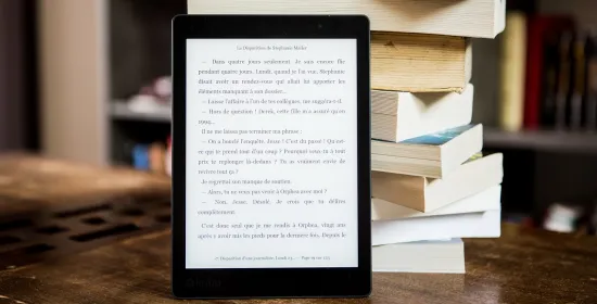 Ebook met gedrukte boeken op de achtergrond