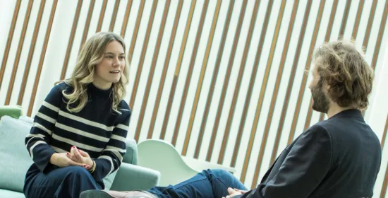 twee mensen op een bank welke een gesprek voeren