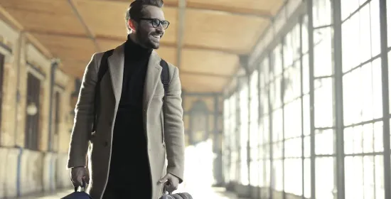 man met koffer in treinstation