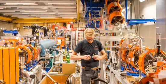 Employee of HFML-FELIX next to equipment