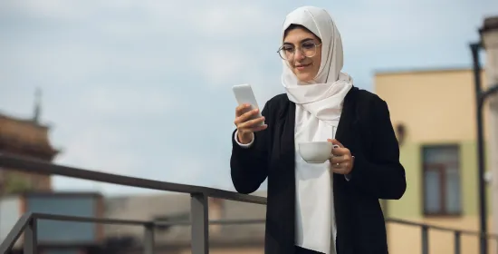 Vrouw met kop koffie en smartphone