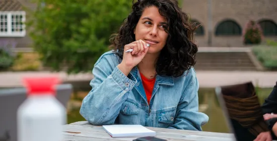 An employee sitting outside listening to someone