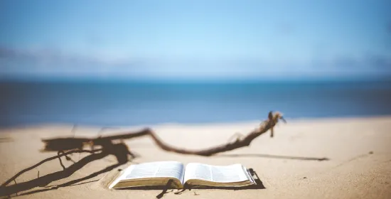 Een opengeslagen boek op een zandstrand