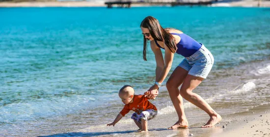 Moeder met baby op het strand