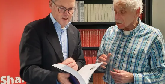 🎓Frans Keune (rechts op de foto) presenteert trots zijn boek aan Prof. Dr. T.M. Heskes vice-decaan Radboud Faculteit der Natuurwetenschappen, Wiskunde en Informatica (foto links).
