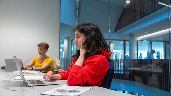 Een student is aan het werk op z'n laptop op de campus van de Radboud Universiteit.