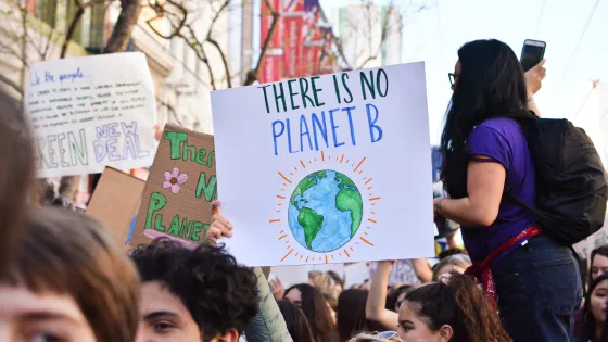 climate protest with someone holding a sign reading 'there is no planet B'
