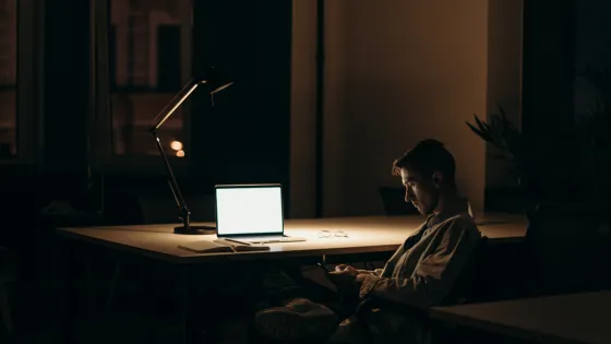 Man in donkere kamer met laptop