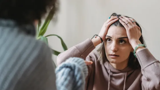 Vrouw zit met de handen in het haar