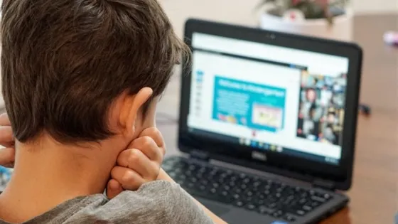 A child reading something on a laptop
