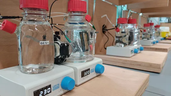 Several glass bottles marked BES1, BES2, etc, in a laboratory situation