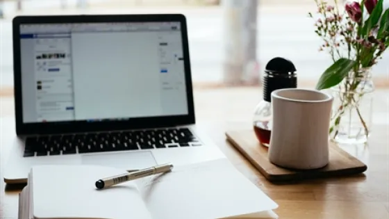 Pen en schrijfblok liggen klaar achter de laptop
