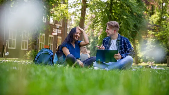 Studenten zitten te kletsen buiten op de campus