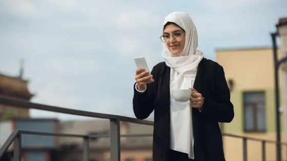 Vrouw met kop koffie en smartphone