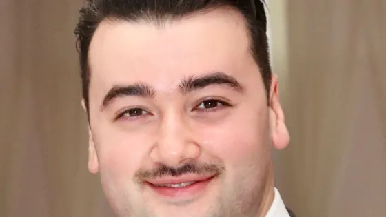 Picture of a young man with short hair and a mustache 